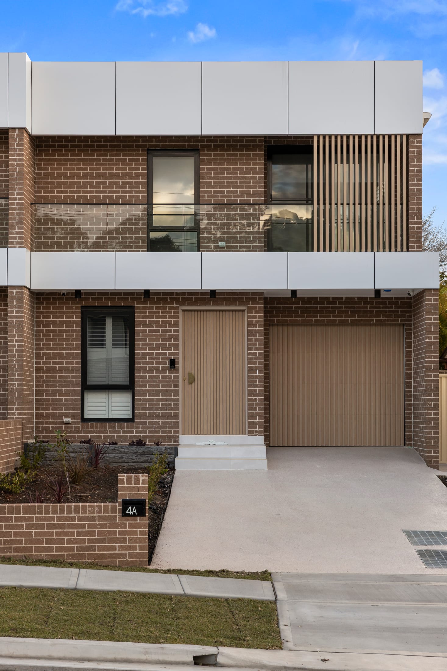 Munro Greystanes duplex with Light Oak timber-look aluminium battens framing the modern facade