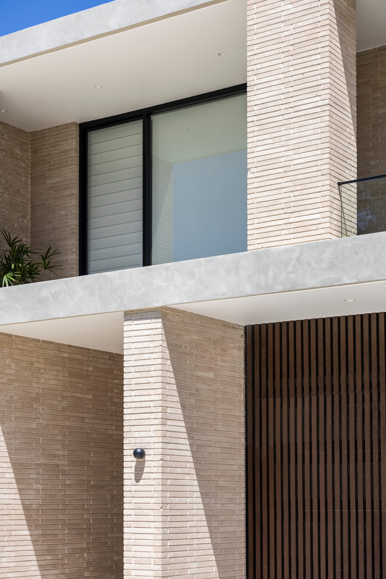 Sydney residence — stacked Burnt Oak timber-look battens and concrete cladding against a blue sky